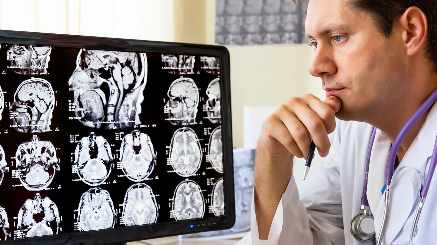 Doctor reviewing scans on computer monitor